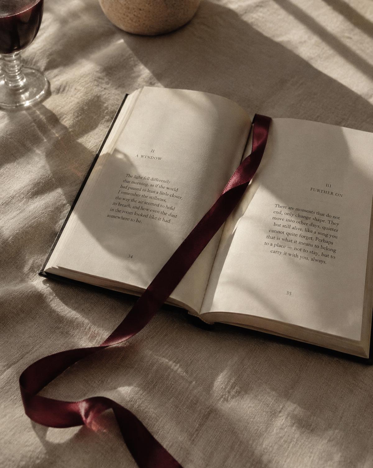 Livro aberto com uma fita vinho atravessando as páginas